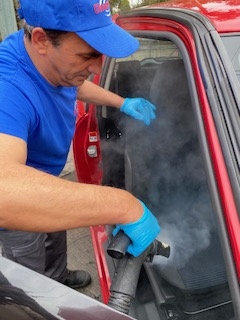 Εργάτης που καθαρίζει το εσωτερικό ενός αυτοκινήτου
